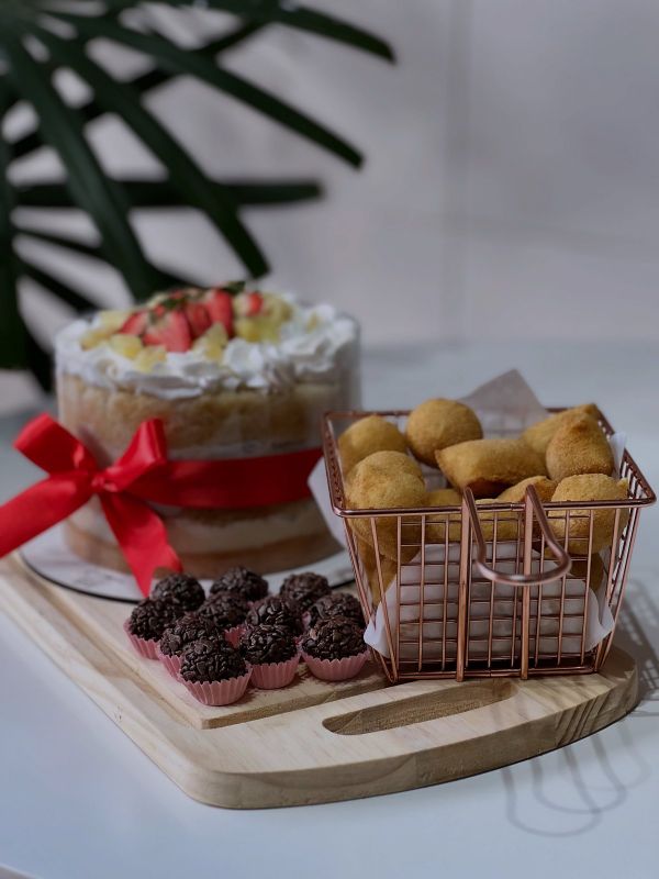 Mesa de festa com bolo, salgadinhos e brigadeiros