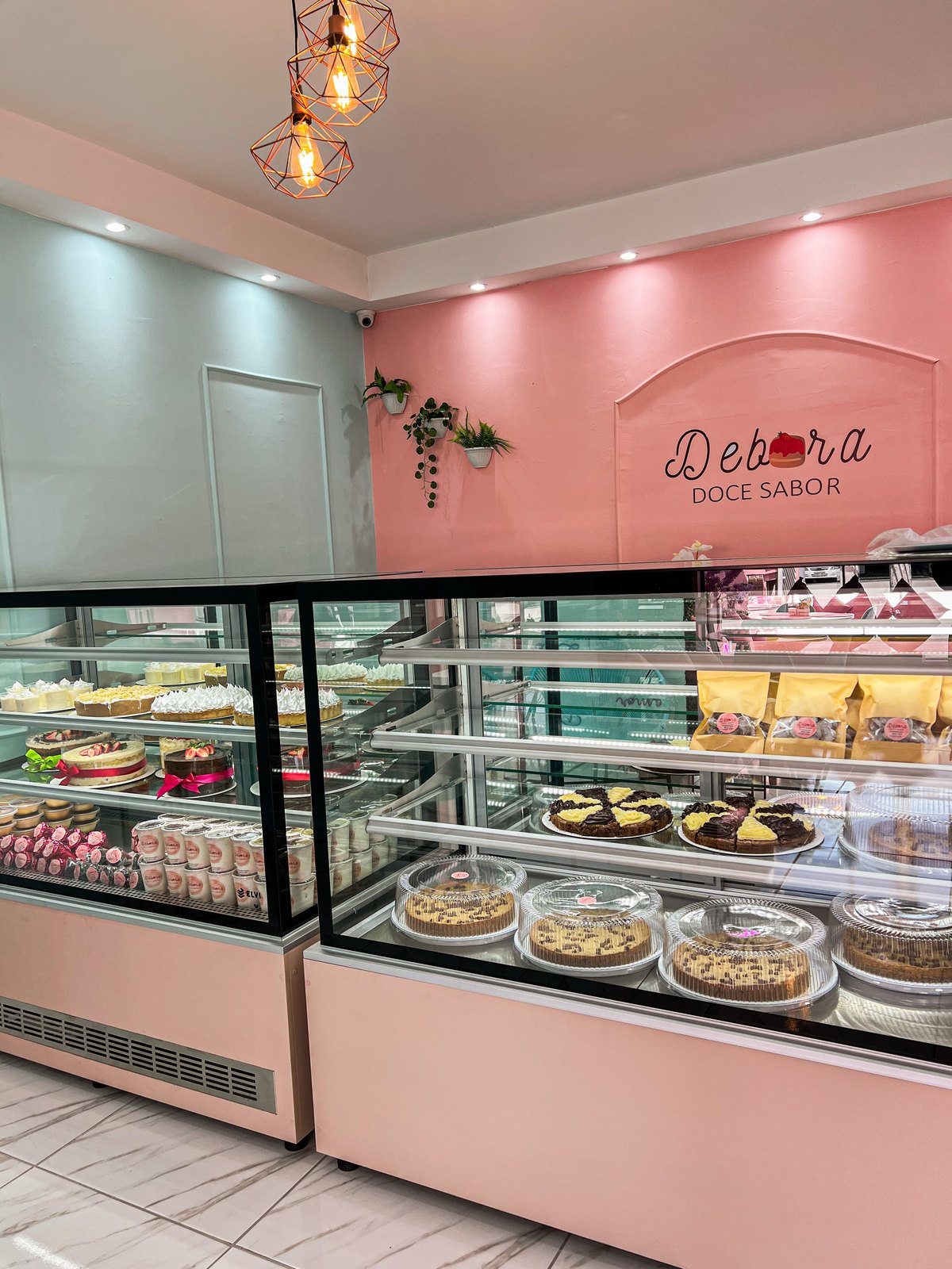 Vitrine de doces da loja Vila Romana com o letreiro Débora Doce Sabor